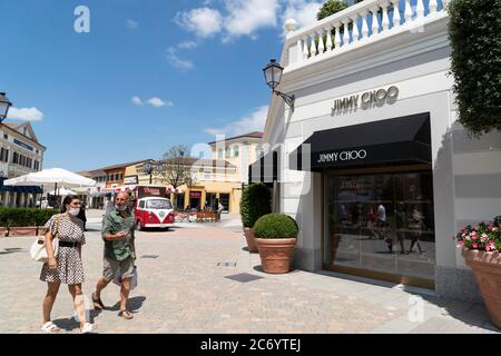 SERRAVALLE SCRIVIA, ITALIE - JUILLET 12 2020 - beaucoup de gens achetant des articles de mode au début de la boutique de créateurs Vente saison de port masque après covid Banque D'Images