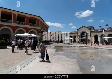 SERRAVALLE SCRIVIA, ITALIE - JUILLET 12 2020 - beaucoup de gens achetant des articles de mode au début de la boutique de créateurs Vente saison de port masque après covid Banque D'Images