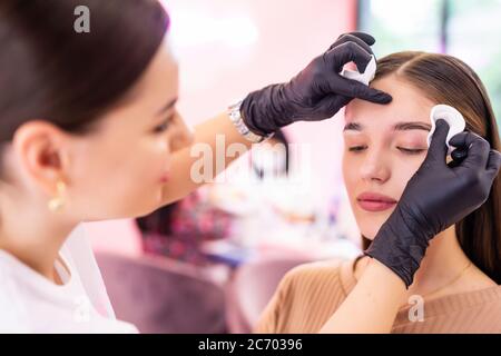 Arbise artiste nettoyer le visage avec l'éponge professionnel de la jeune femme Banque D'Images