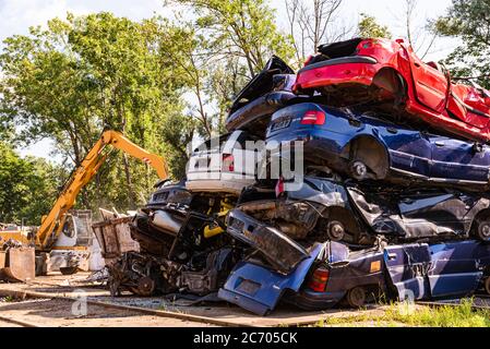 Les voitures se sont empilées les unes sur les autres dans un jardin. Banque D'Images