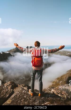 Homme avec sac à dos voyage seul randonnée en plein air aventure vacances actif vie saine randonneur levé les mains sur le sommet de la montagne au-dessus des nuages mental il Banque D'Images