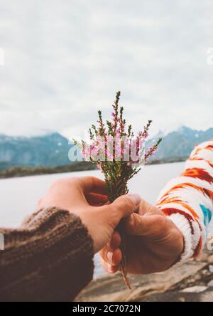 Main donnant fleurs bouquet romantique couple dans l'amour datant voyage relation de plein air style de vie vacances en Norvège Banque D'Images