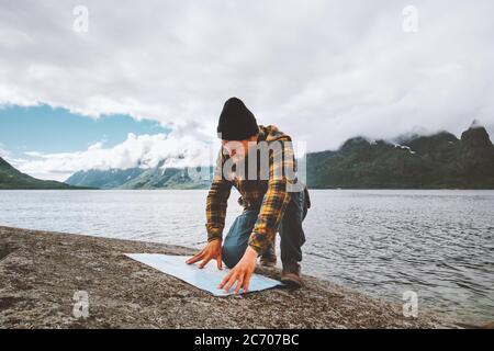 Homme regardant une carte planification vacances itinéraire voyage voyage seul en Norvège active aventure style de vie sauvage survie mer fjord et montagnes brumeuses Banque D'Images