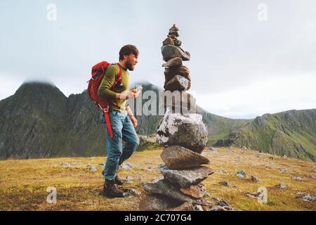 Homme randonnée avec sac à dos utilisation de smartphone pour la navigation rock cairn marquage itinéraire sur sommet de montagne Voyage sain style de vie concept active aventure Banque D'Images