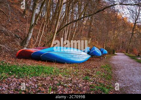 Les canoës bleus se trouvent dans les quartiers d'hiver, sur le côté du chemin dans une forêt. Banque D'Images