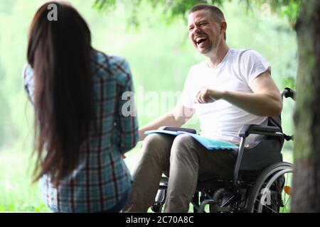 Homme handicapé homme avec petite amie souriant sur le portrait de marche du parc Banque D'Images