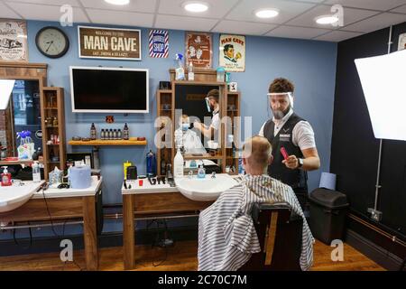 Carmarthen, Carmarthenshire, pays de Galles, Royaume-Uni. 13 juillet 2020. Un jeune homme a une coupe de cheveux dans Blue Street Barbers que les barbers et les coiffeurs rouvrent au pays de Galles avec l'assouplissement des restrictions de verrouillage de coronavirus / Covid-19. Crédit: Gruffydd Ll. Thomas/Alay Live News Banque D'Images