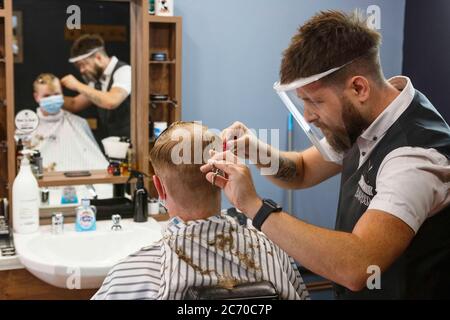 Carmarthen, Carmarthenshire, pays de Galles, Royaume-Uni. 13 juillet 2020. Un jeune homme a une coupe de cheveux dans Blue Street Barbers que les barbers et les coiffeurs rouvrent au pays de Galles avec l'assouplissement des restrictions de verrouillage de coronavirus / Covid-19. Crédit: Gruffydd Ll. Thomas/Alay Live News Banque D'Images