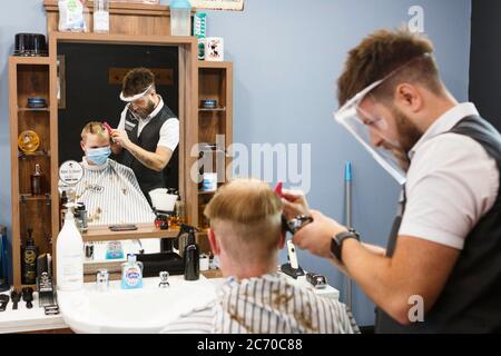 Carmarthen, Carmarthenshire, pays de Galles, Royaume-Uni. 13 juillet 2020. Un jeune homme a une coupe de cheveux dans Blue Street Barbers que les barbers et les coiffeurs rouvrent au pays de Galles avec l'assouplissement des restrictions de verrouillage de coronavirus / Covid-19. Crédit: Gruffydd Ll. Thomas/Alay Live News Banque D'Images