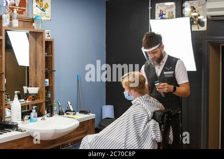 Carmarthen, Carmarthenshire, pays de Galles, Royaume-Uni. 13 juillet 2020. Un jeune homme a une coupe de cheveux dans Blue Street Barbers que les barbers et les coiffeurs rouvrent au pays de Galles avec l'assouplissement des restrictions de verrouillage de coronavirus / Covid-19. Crédit: Gruffydd Ll. Thomas/Alay Live News Banque D'Images