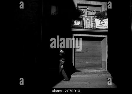 Un homme marche à côté d'une maison aux drapeaux séparatistes et nationalistes et aux affiches dans le village de Mollo, dans les Pyrénées catalanes. Date: 28/09/2017. Photo: Xabier Mikel Laburu. Les villages intérieurs du nord de la Catalogne devraient voter massivement pour la séparation de l'État espagnol. Banque D'Images