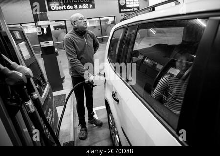 Salvador Casalprim 'aka. Viroscaa', remplit le réservoir d'essence dans une station d'essence d'Olot, en Espagne, tandis que sa fille regarde par la fenêtre, sur leur chemin à Bruxelles pour aider à la manifestation en faveur de la République catalane. Date: 05/12/2017. Photo: Xabier Mikel Laburu. Environ 45.000 Catalans ont manifesté à Bruxelles pour l'indépendance de la Catalogne le 7 décembre. Banque D'Images