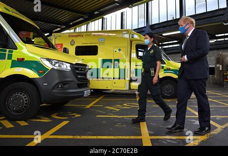 Le Premier ministre Boris Johnson, portant un masque, parle avec Cindy Fu, un paramédic, lors d'une visite au siège du London Ambulance Service NHS Trust. Banque D'Images