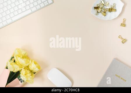 Flat Lay blogger ou indépendant espace de travail avec Bloc-notes, clavier et un bouquet de tulipes de pivoine jaune Banque D'Images