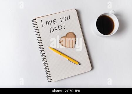 Notez que j'adore papa dans le Bloc-notes sur un fond blanc. Mots manuscrits. Fête des pères. Banque D'Images