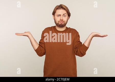 Je ne sais pas! Portrait d'un homme confus sans indice avec la barbe portant un sweat-shirt haussant les épaules dans le brewilderment, exprimant des doutes, réponse ambiguë Banque D'Images
