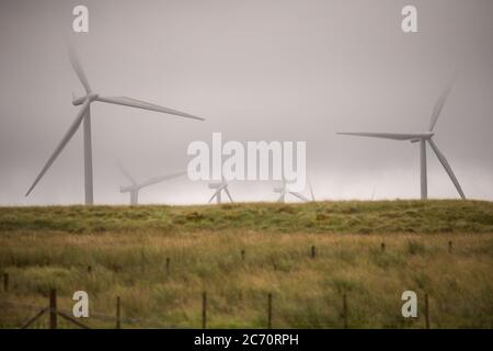 Whitelee, Écosse, Royaume-Uni. 13 juillet 2020. Photo : Scottish Power renouvelables parc éolien à Whitelee dans Ayrshire, vu par une journée humide et venteuse avec des nuages bas masquant certaines des pales de turbine qui semblent coller dans le nuage bas. Les éoliennes sont-elles vertes ? Les lames ne sont pas recyclables actuellement, mais davantage d'investissements sont nécessaires pour atteindre les objectifs d'énergie verte des Scotlands et du Royaume-Uni. Crédit : Colin Fisher/Alay Live News Banque D'Images