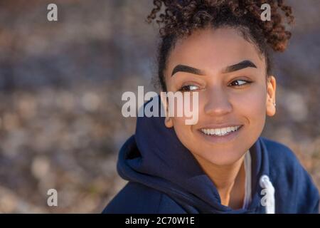Portrait plein air de belle happy mixed race African American girl biracial adolescent femme jeune femme souriante avec dents parfait bleu portant un ho Banque D'Images