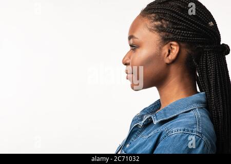 Fille avec la coiffure tressée posant sur fond blanc, Portrait de profil Banque D'Images