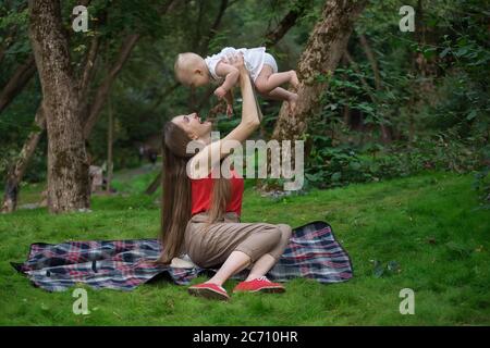 Mère joue avec bébé à l'extérieur. Plaisir aimant mère et bébé Banque D'Images