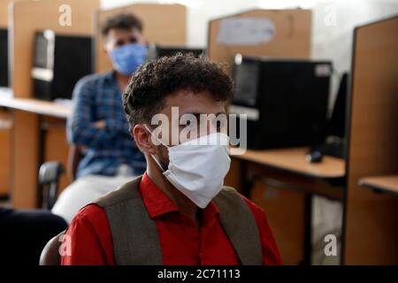 Sanaa, Yémen. 12 juillet 2020. Les étudiants portant un masque facial protecteur sont assis à distance alors qu'ils reprennent leurs études dans une université de Sanaa, Yémen, le 12 juillet 2020. Credit: Mohammed Mohammed/Xinhua/Alay Live News Banque D'Images