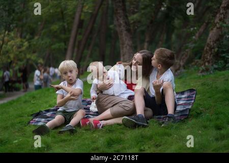 Trois enfants et une mère pique-nique en été. Concept de togethness avec les enfants. Famille amicale frères et sœurs. Banque D'Images
