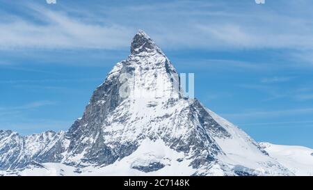 Vue emblématique du sommet du Cervin de neige avec ciel bleu et quelques nuages en arrière-plan, Suisse Banque D'Images
