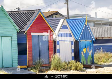 Des cabanes de plage en bois colorées par une journée ensoleillée. Banque D'Images