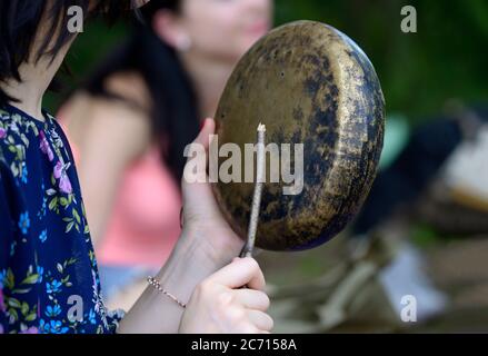 Jeune femme jouant du gong, cloche du temple tibétain, pour méditer Banque D'Images