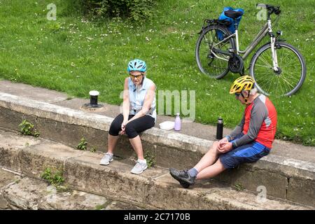 Deux cyclistes âgés assis dehors Banque D'Images