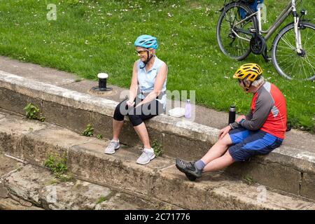 Deux cyclistes âgés assis dehors Banque D'Images