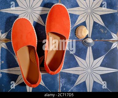 chaussures orange sur carrelage bleu de style marin Banque D'Images