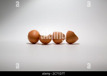 Coquilles d'œufs de poulet cassées en ligne isolée sur fond blanc avec espace de copie Banque D'Images