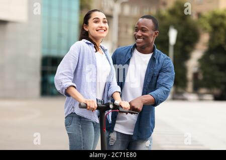 Couple ayant une agréable promenade sur le scooter électrique de kick Banque D'Images