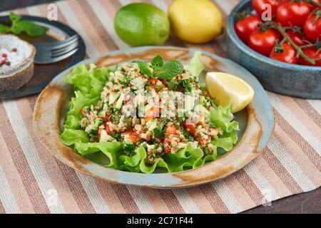 Salade de tabouleh avec quinoa. Cuisine orientale avec mélange de légumes, régime végétalien. Vue latérale, ancienne plaque Banque D'Images