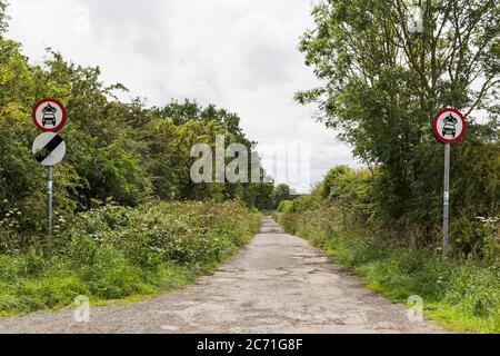 Un panneau no Motor Vehicle avec un panneau national de limite de vitesse sur une voie nationale, Royaume-Uni Banque D'Images