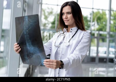 Jeune femme médecin en train de regarder une radiographie à l'hôpital. Banque D'Images