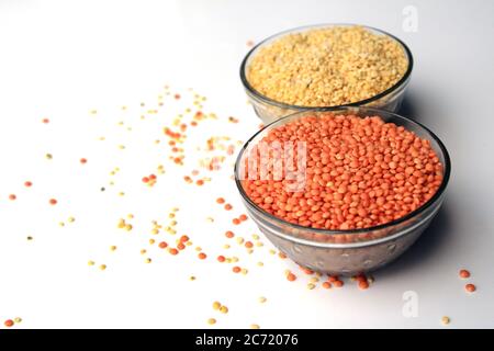 Pile de lentilles rouges non cuites et de pois de pigeon. Mung haricots et lentilles rouges dans deux bols isolés sur fond blanc. Banque D'Images