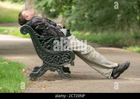 LONDRES, ROYAUME-UNI. 13 juillet 2020. Un homme qui s'est mis à sommer sur un banc de parc à Green Park prend un peu de sommeil lors d'une journée ensoleillée et chaude à Londres. Crédit : amer ghazzal/Alay Live News Banque D'Images