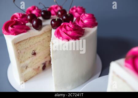 Gâteau macro à la cerise arrosoir avec fourchette. Photo sur fond bleu Banque D'Images