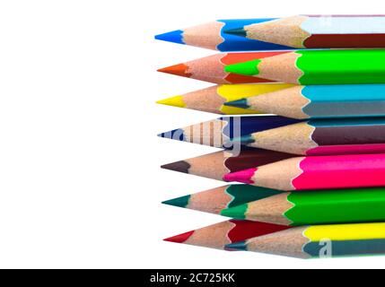 Vue de dessus de la rangée de différents crayons de bois de couleur placés sur un autre sur du papier blanc Banque D'Images