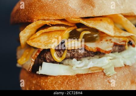 Circulaire Burger. Hamburger au fromage avec viande grillée, fromage, salade et rondelles d'oignon. Gros plan de délicieux hamburgers maison frais sur fond bleu écorce Banque D'Images