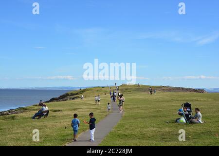 Barry Island, Vale de Glam. / pays de Galles - juin 24 2020: COVID-19 social distance sur la plage. Le soleil est chaud et les amis et les familles s'assoient en groupes 2 Banque D'Images