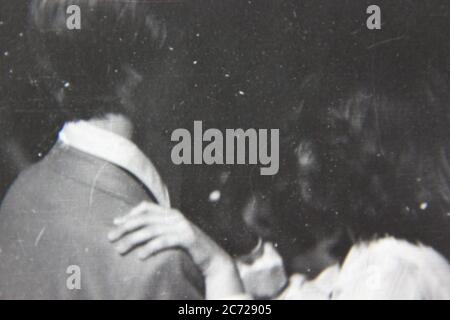 Belle photo de style de vie noir et blanc vintage des années 70 d'un couple adolescent dansant lors d'un événement formel. Banque D'Images