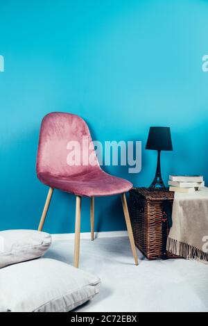 Chaise moderne en velours rose et coffre en osier Banque D'Images