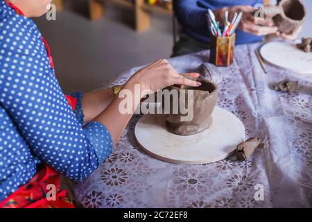 Vue rapprochée - femme professionnelle potter faisant une tasse dans atelier de poterie, studio. Fait main, petite entreprise, conception de travail de fabrication Banque D'Images