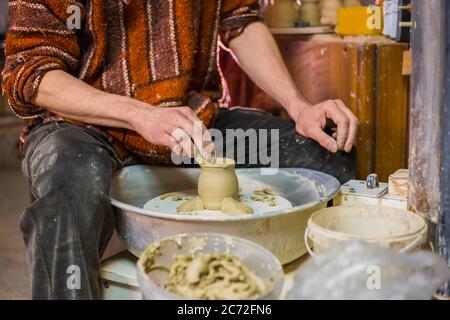 Professionnel hommes potter mug en forme avec l'outil à l'atelier de poterie, studio. Artisanat, art et concept fait main Banque D'Images