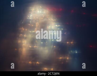 Lumières de ville floues. Arrière-plan abstrait en soirée pluvieuse Banque D'Images