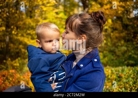 portrait d'une jeune belle mère tient un tout-petit dans ses bras et l'embrasse doucement. concept d'amour de maman Banque D'Images