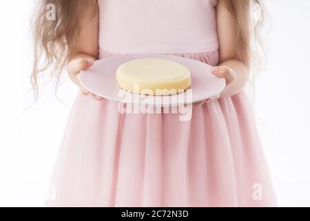 Belle petite fille surprise d'un savoureux cheesecake. Gâteau prêt à manger pour enfant. Banque D'Images